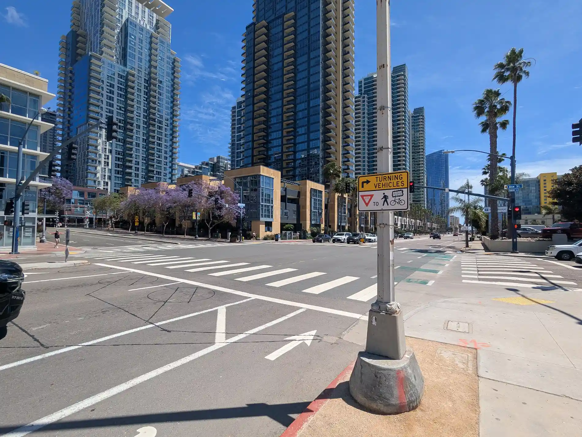 San Diego downtown intersection with pedestrian and bicycle path warning sign.