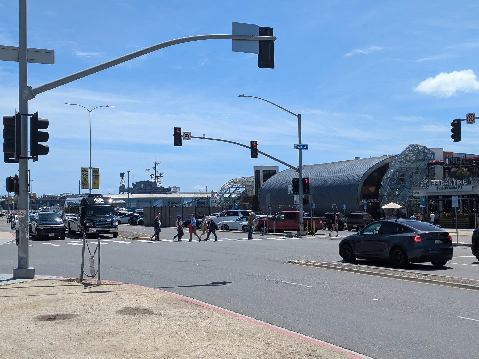 A large San Diego intersection with traffic signals and crossing pedestrians and traffic.