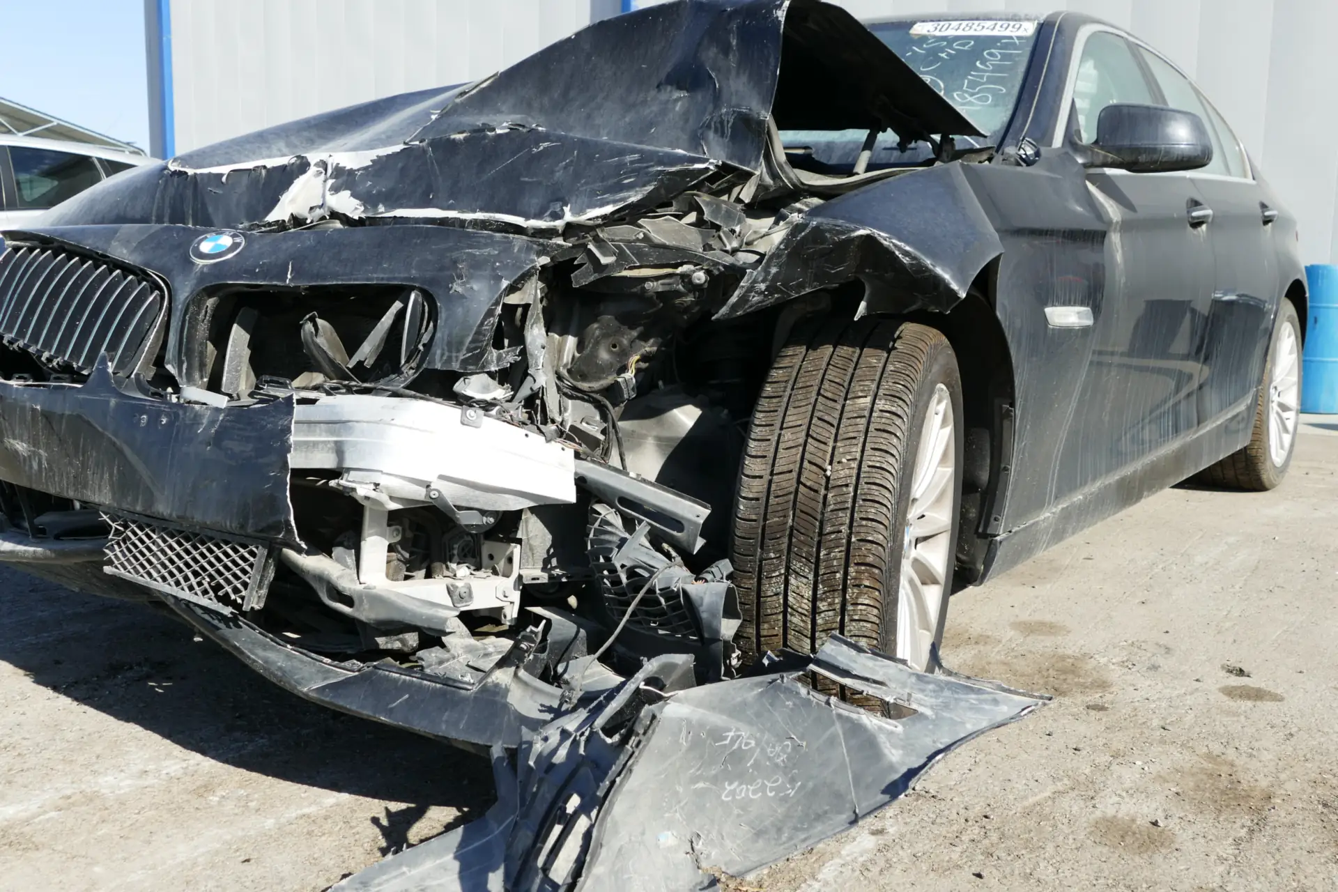 Sedan with severe front-end crush damage, the kind of damage seen in head-on collisions.