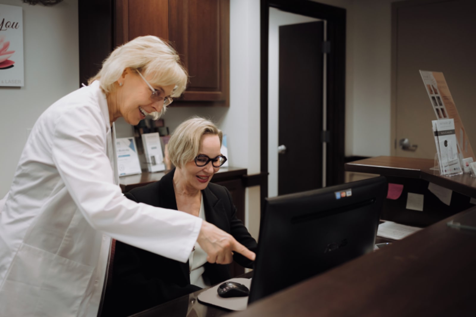 Dentist showing patient digital smile design on computer screen in office
