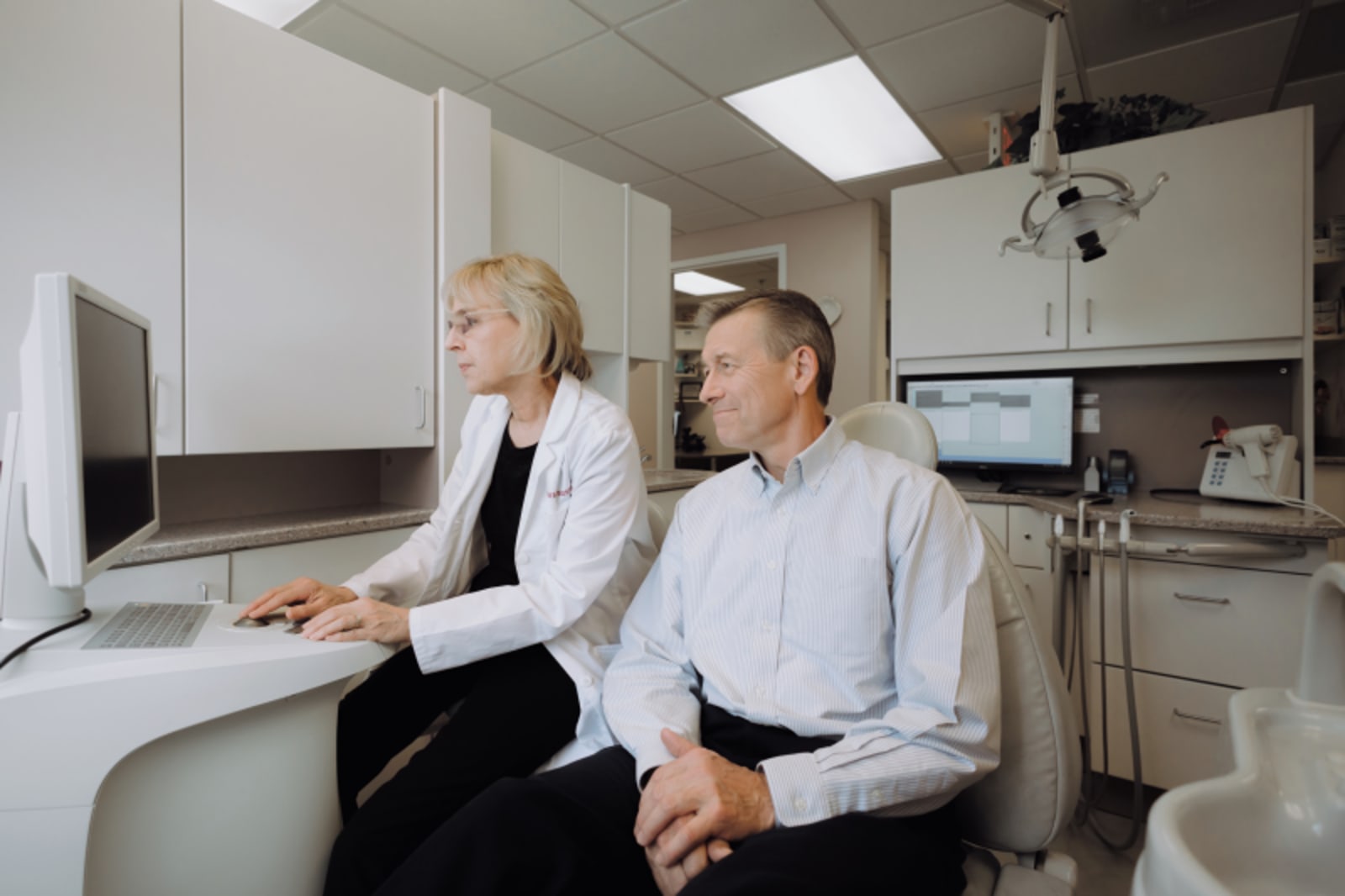 Dentist showing patient Invisalign aligners at treatment consultation
