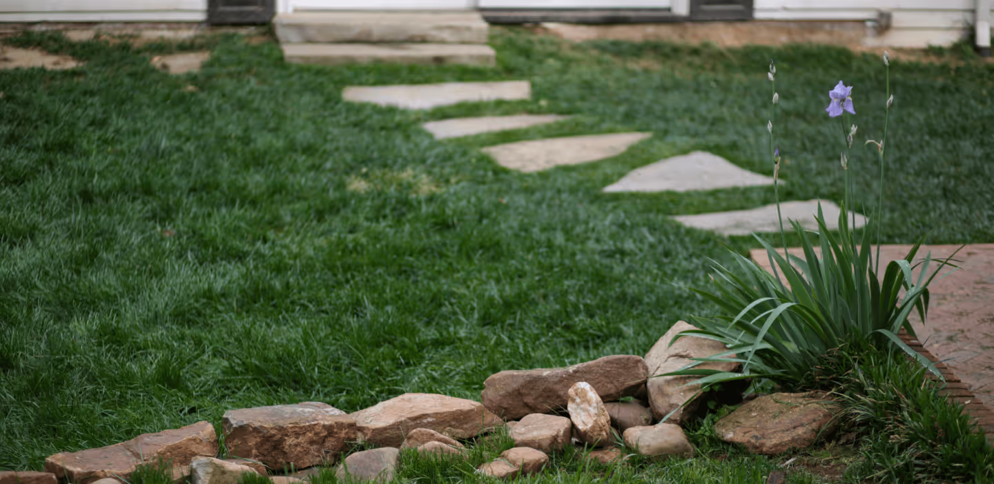 A garden path with stepping stones and a flower bed.