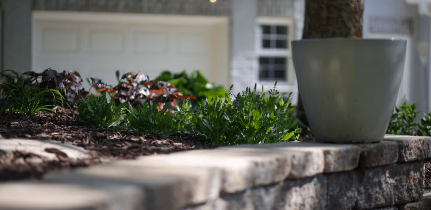 A planter on top of the stone border of a landscape garden