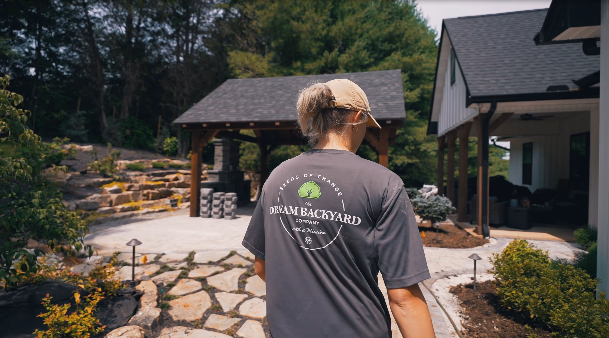 A female worker heading towards a landscaped backyard