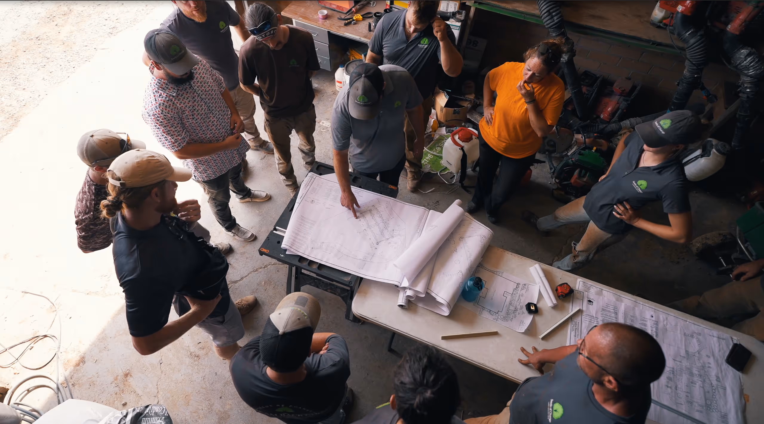 Team gathered around a table discussing project plans and designs