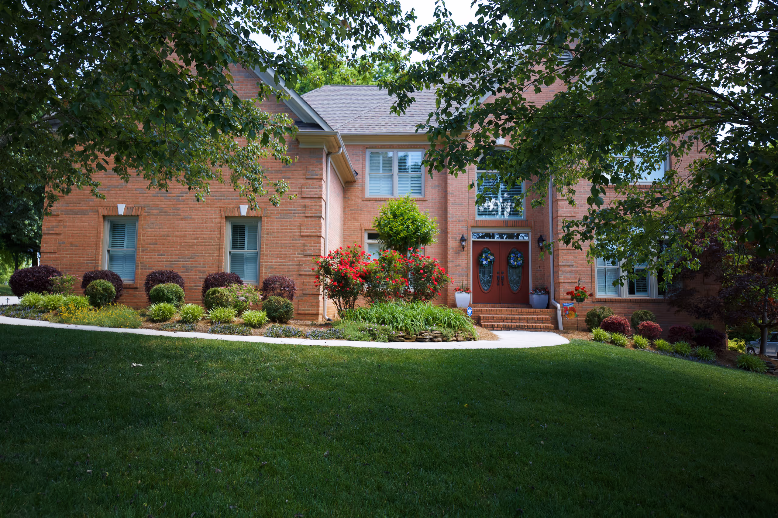A suburban home with a landscaped front yard and a brick facade