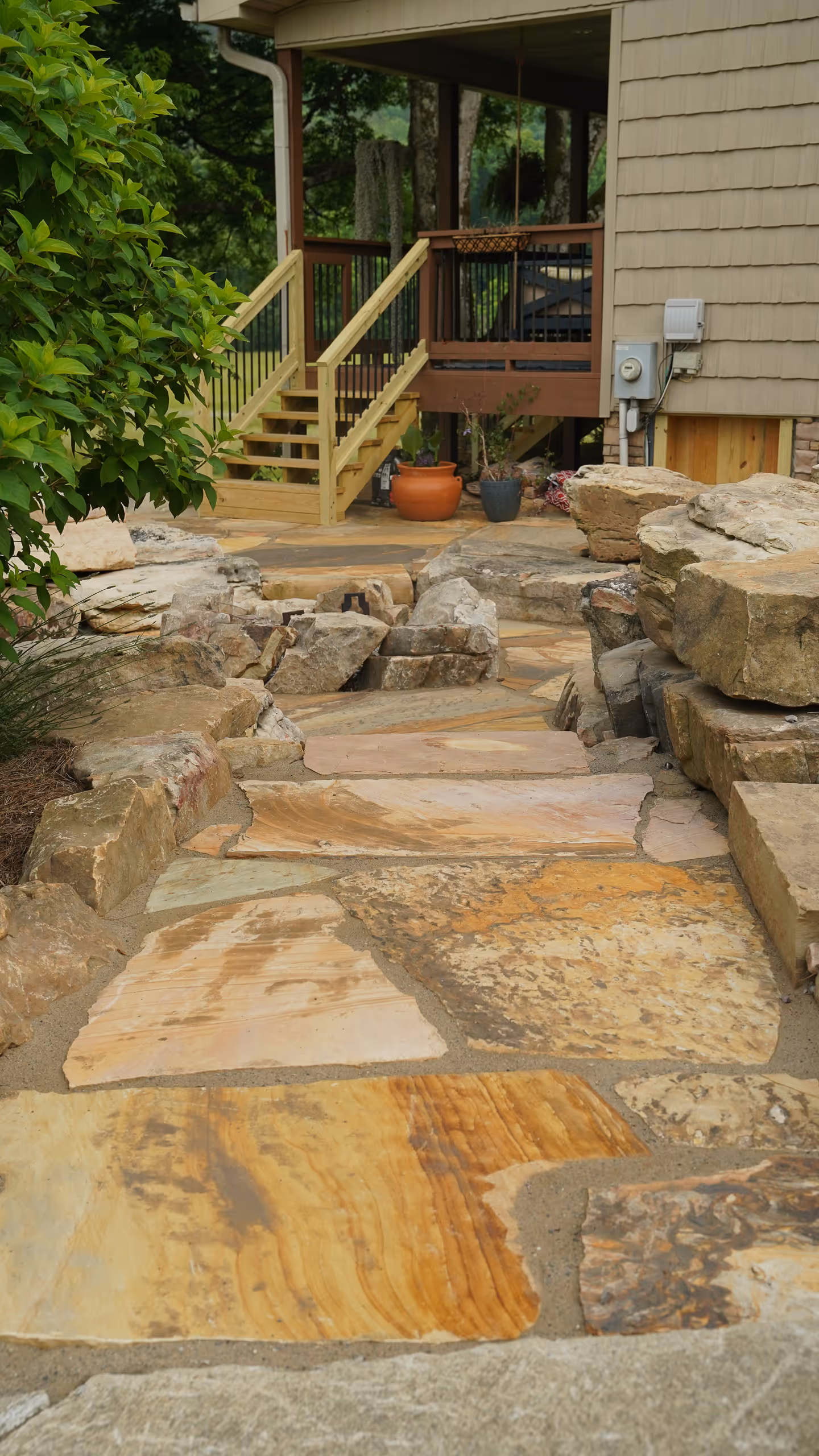 A garden path made of natural stone, leading to a deck and house