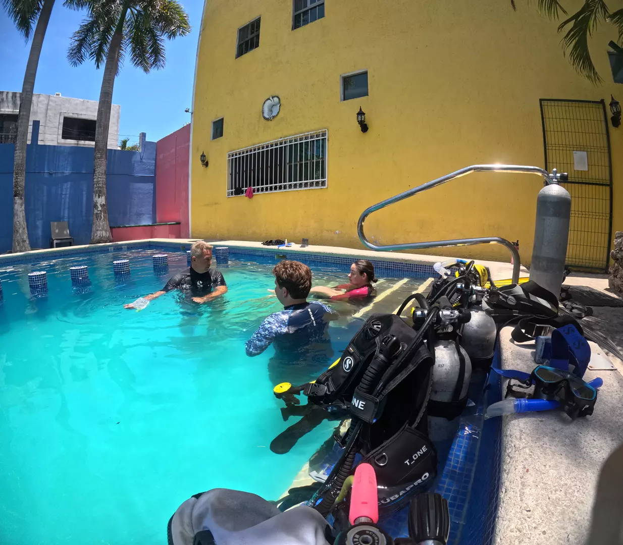 Omar in our training pool with 2 open water students listening to his explanations at the surface