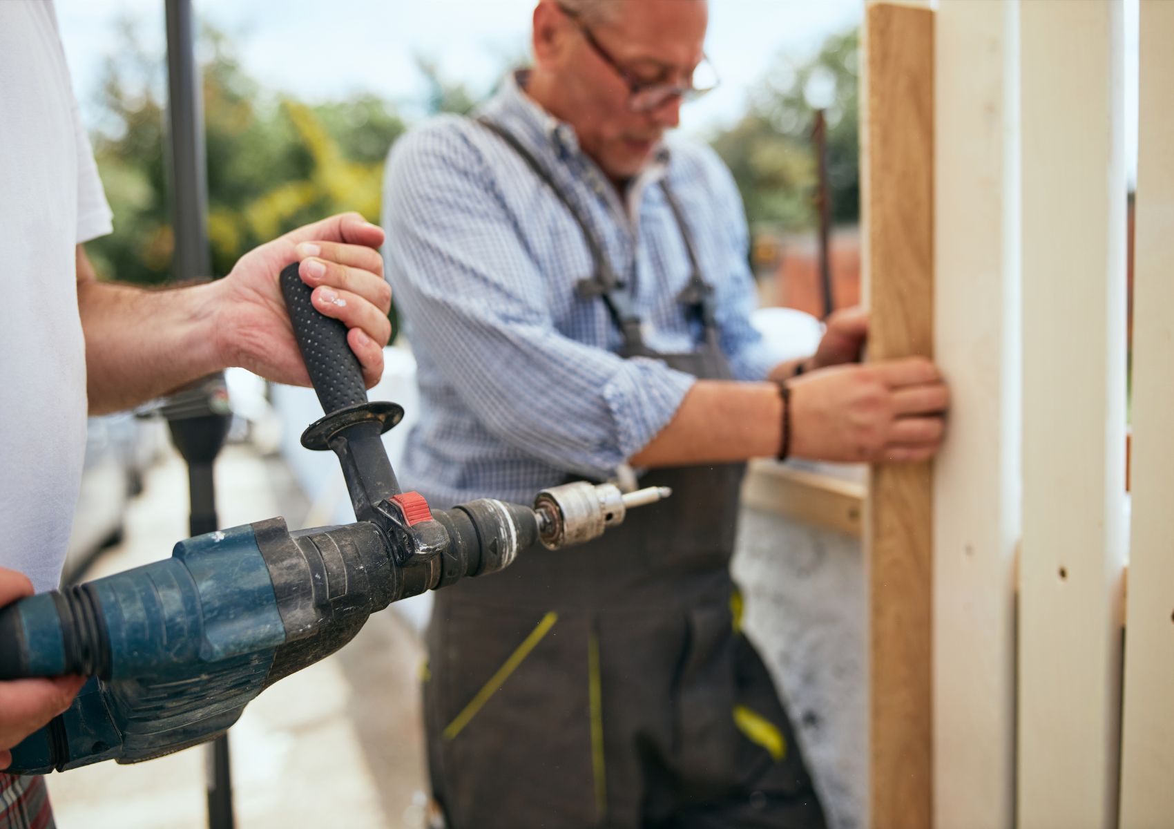 Two fence installers installing wooden fence