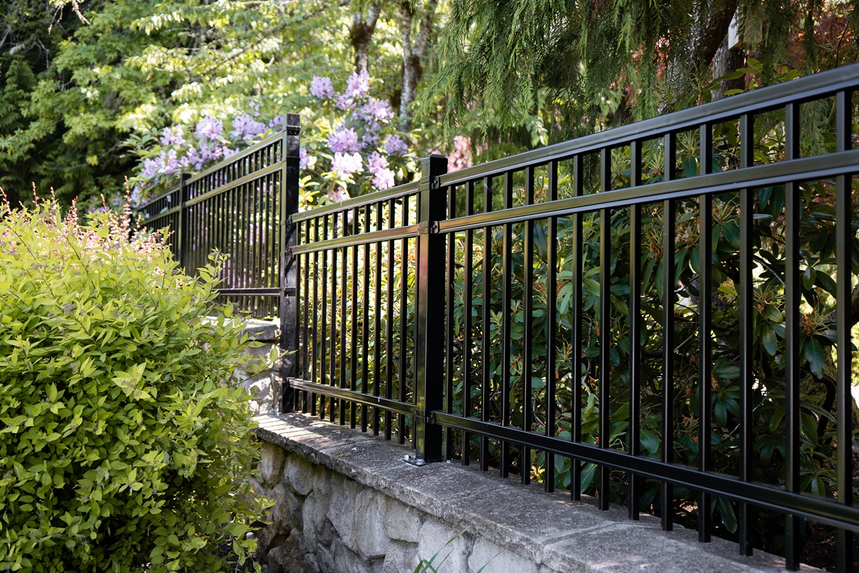 A newly constructed wooden privacy fence with a decorative lattice top section, enclosing a side yard