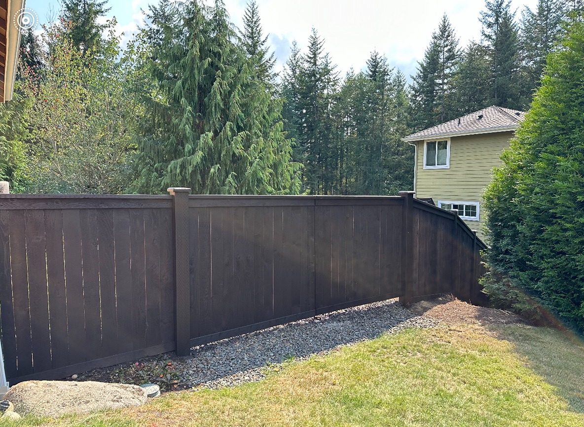 A line of cedar picket fence installed in a sloped terrain in Seattle
