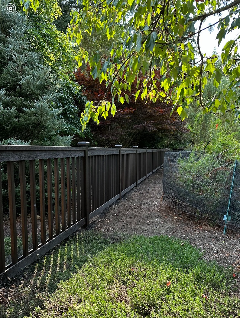 Cedar picket fence surrounded with trees and shrubs in a Snohomish property