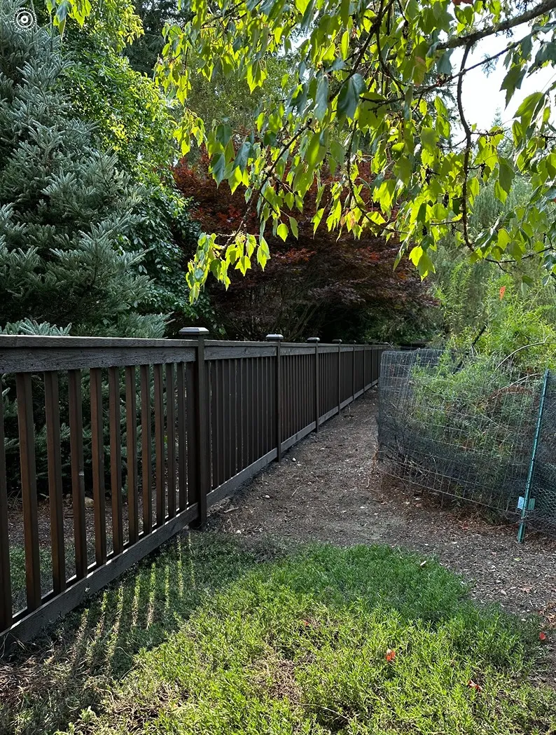 Cedar picket fence surrounded with trees and shrubs in a Snohomish property