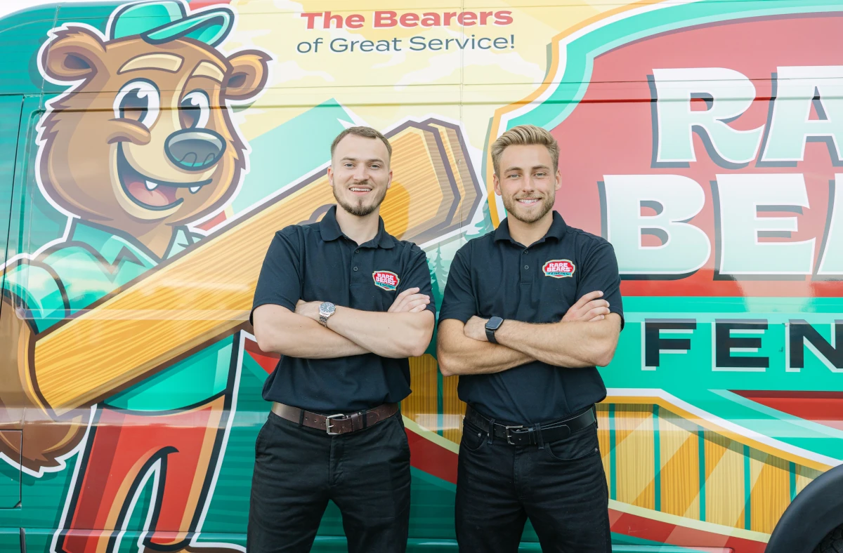 Rare Bears Fencing co-owners with arms crossed in front of the branded company van
