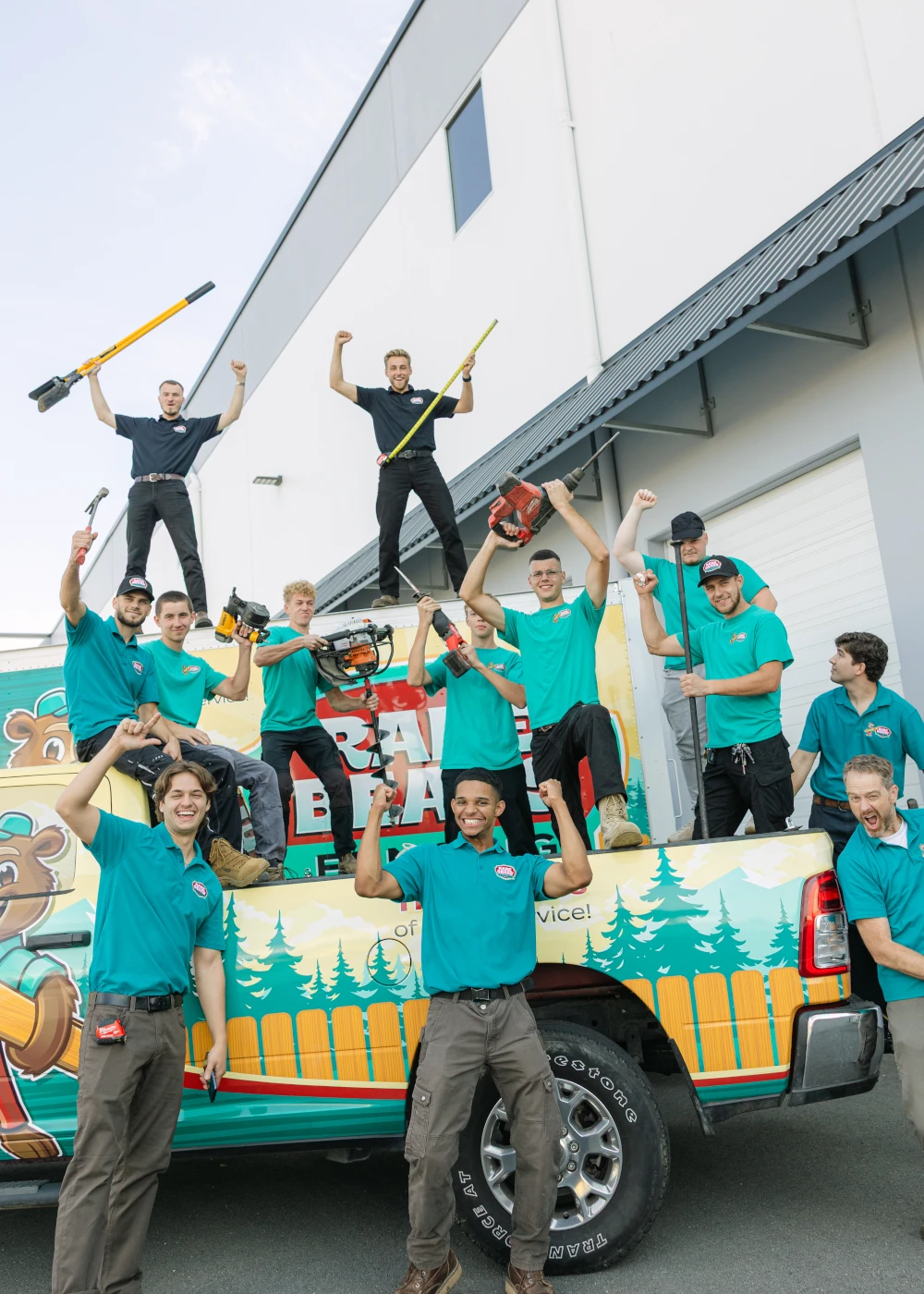 Rare Bears Fencing owners and crew cheering with fencing tools raised on and around a branded company truck