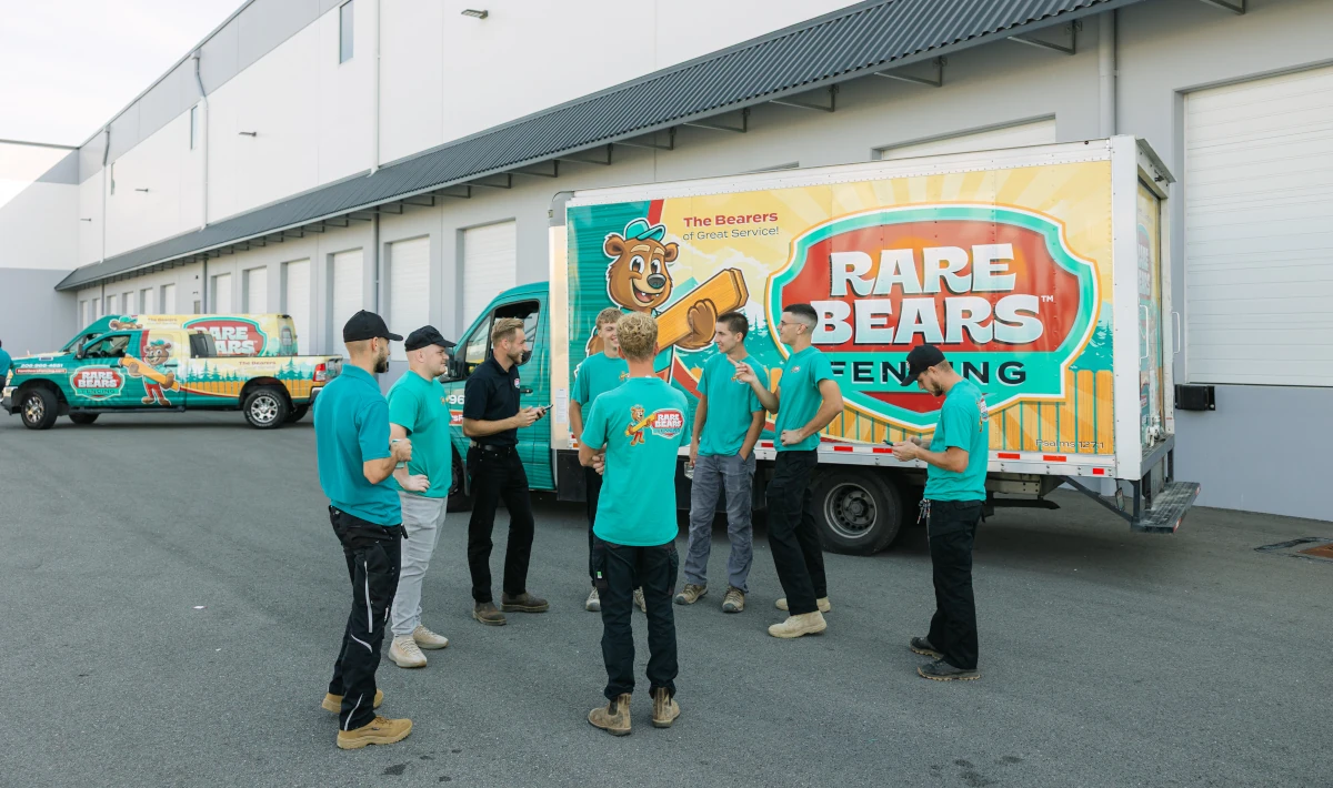 Rare Bears Fencing crew gathered beside a branded box truck outside the company warehouse before a job