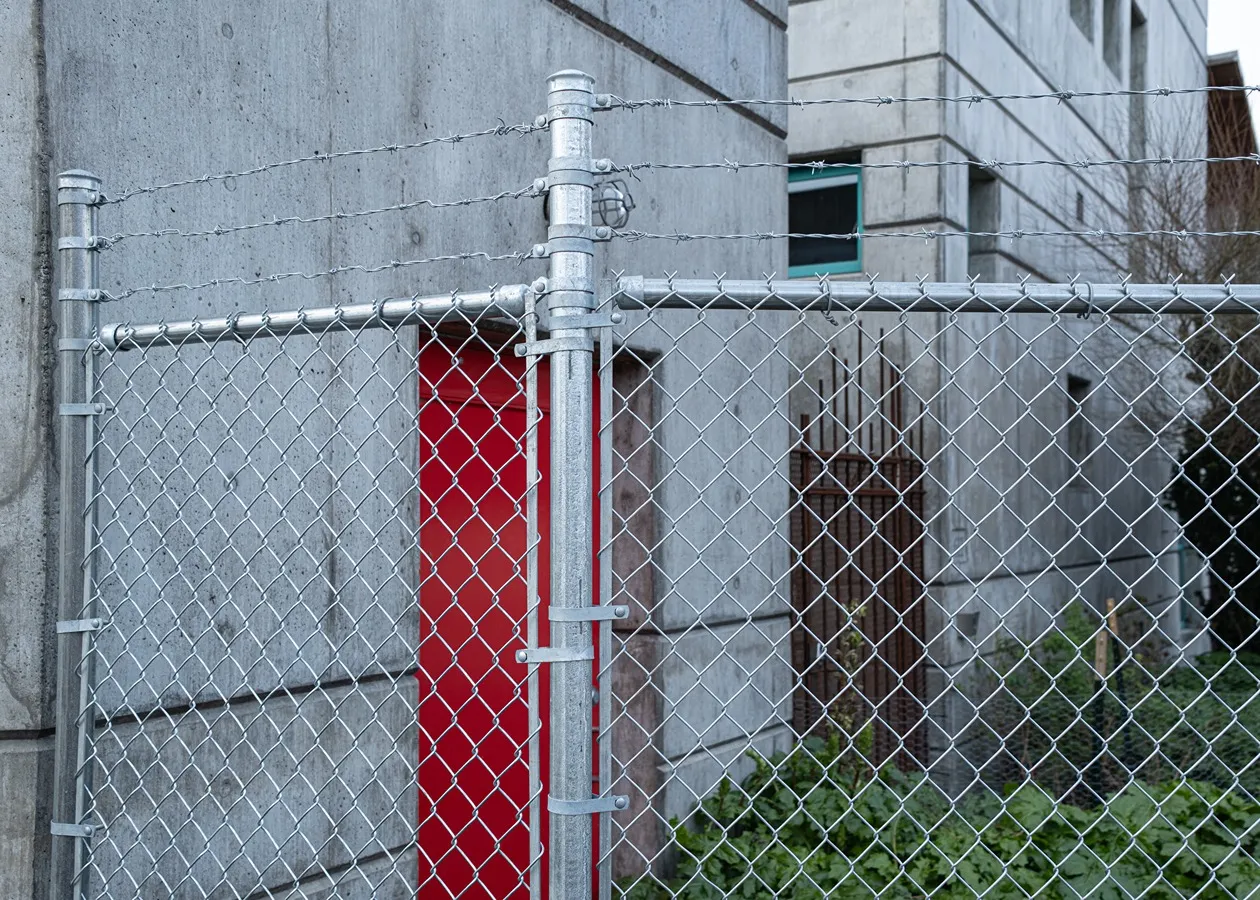 Chain link security fencing with woven PVC privacy slats for partial visibility control at a property