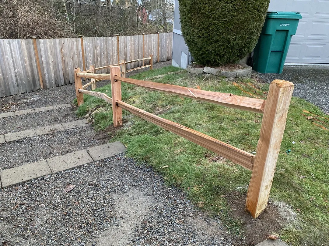 Split rail fence with rustic wood rails and properly set posts at a residential property