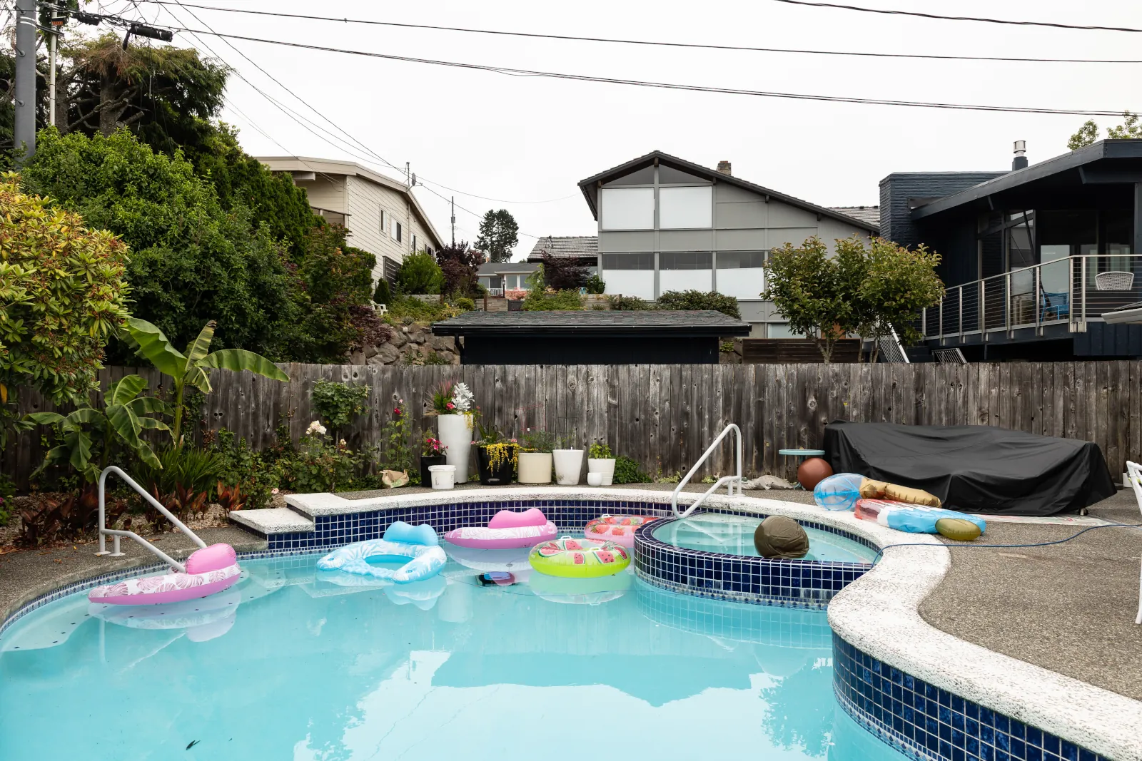 Old weathered wood fence surrounding a backyard swimming pool