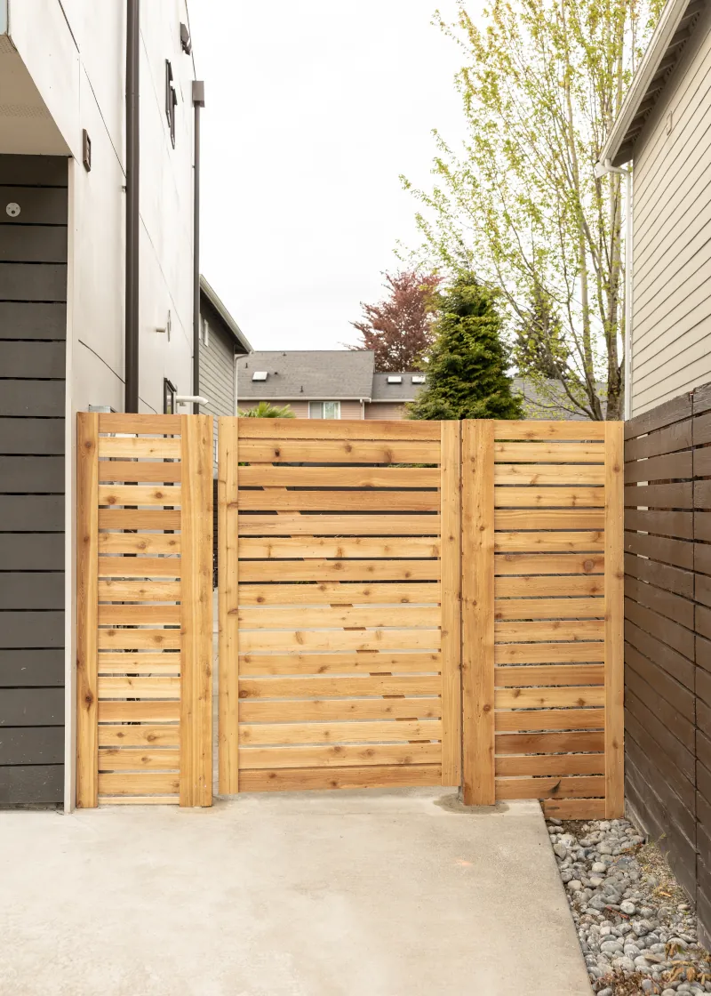 Close-up of a horizontal cedar slat gate and matching side panels between two houses