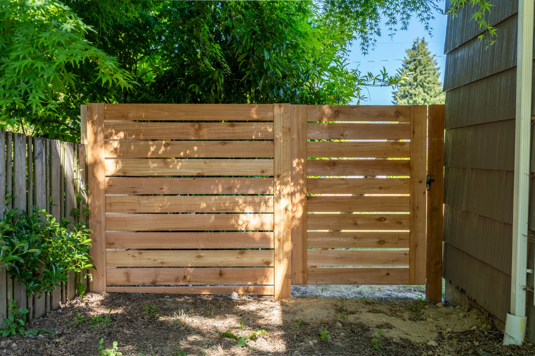 Close-up of horizontal cedar fence gate hardware and alignment