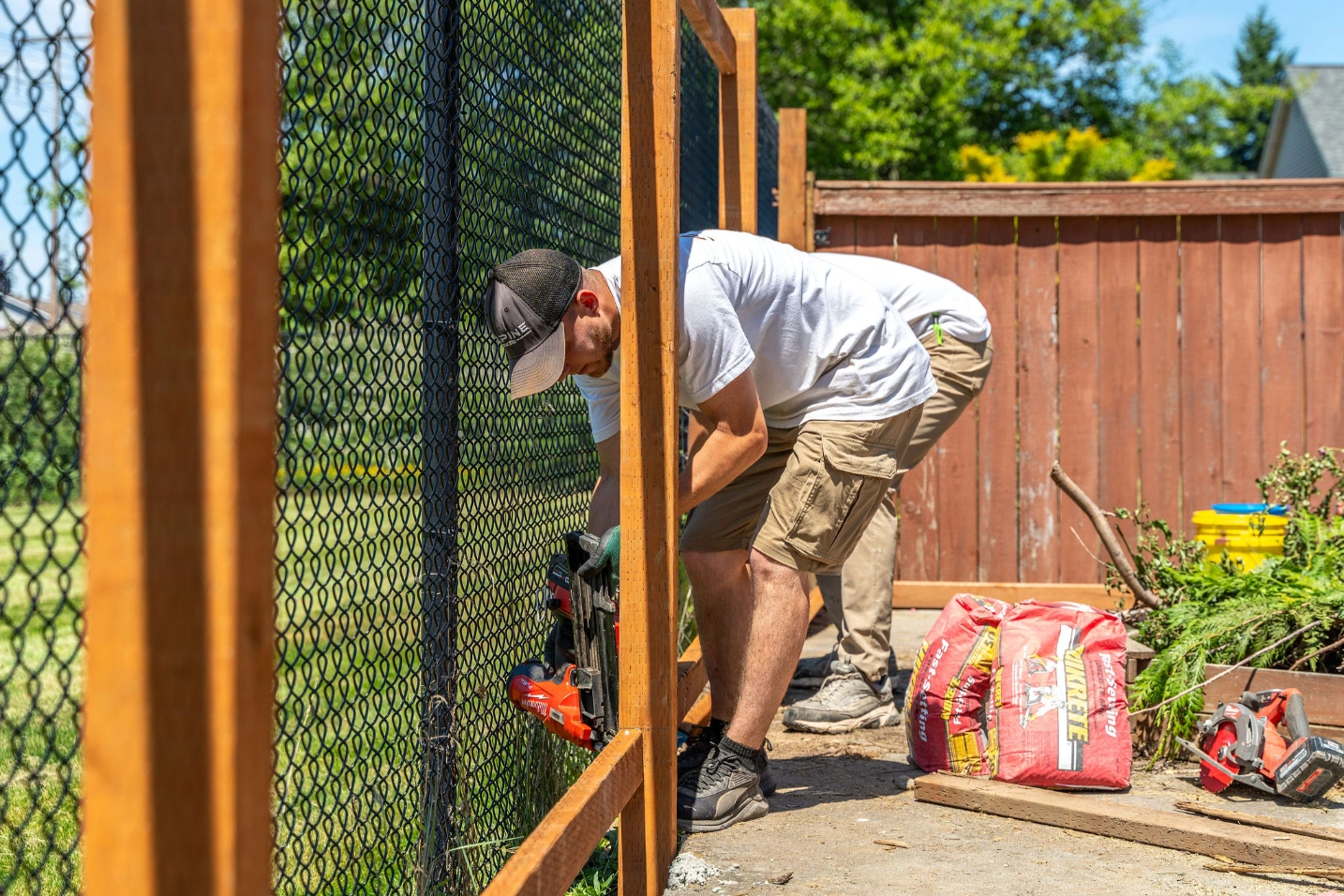 Fence installers aligning cedar rails for consistent spacing on Snohomish residential fence project