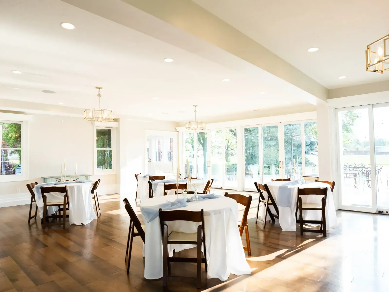 Tables set in a bright room with tall windows