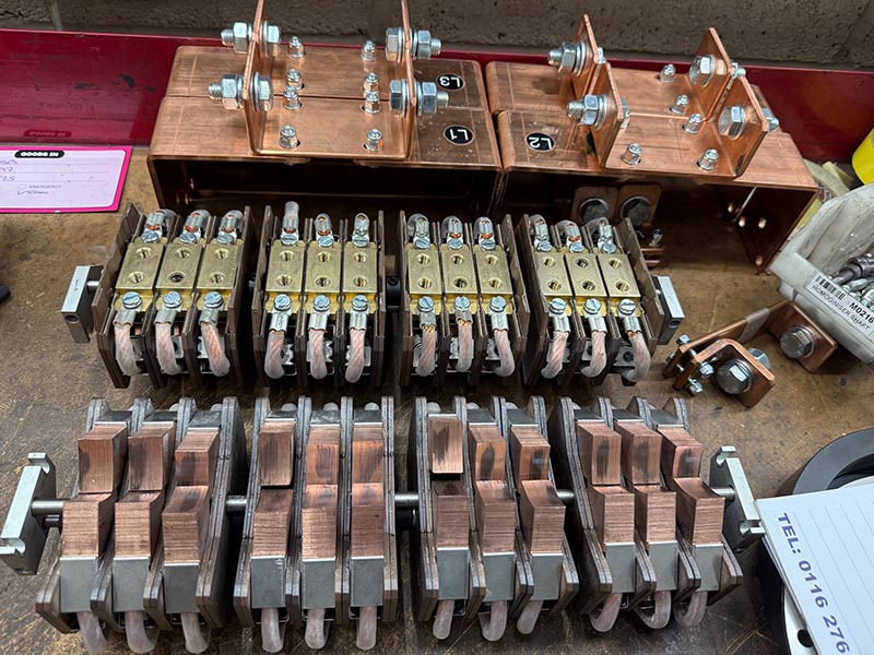 Refurbished brush-gear blocks and copper connections laid out on the bench