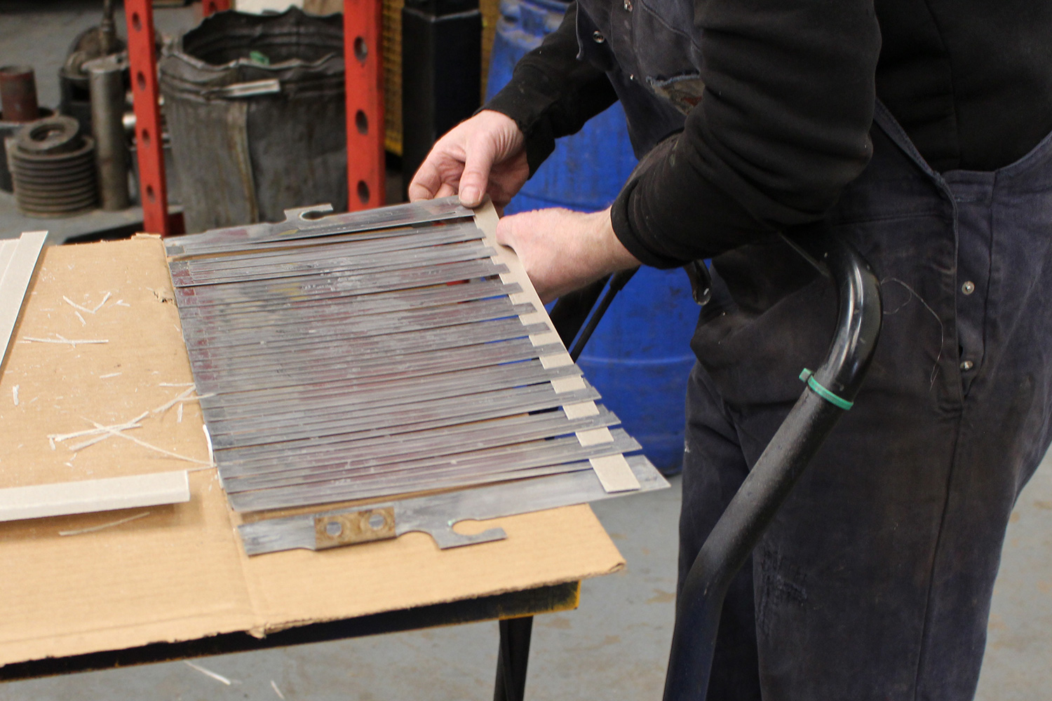 A worker lifting a stack of resistor grid elements out of a resistor bank