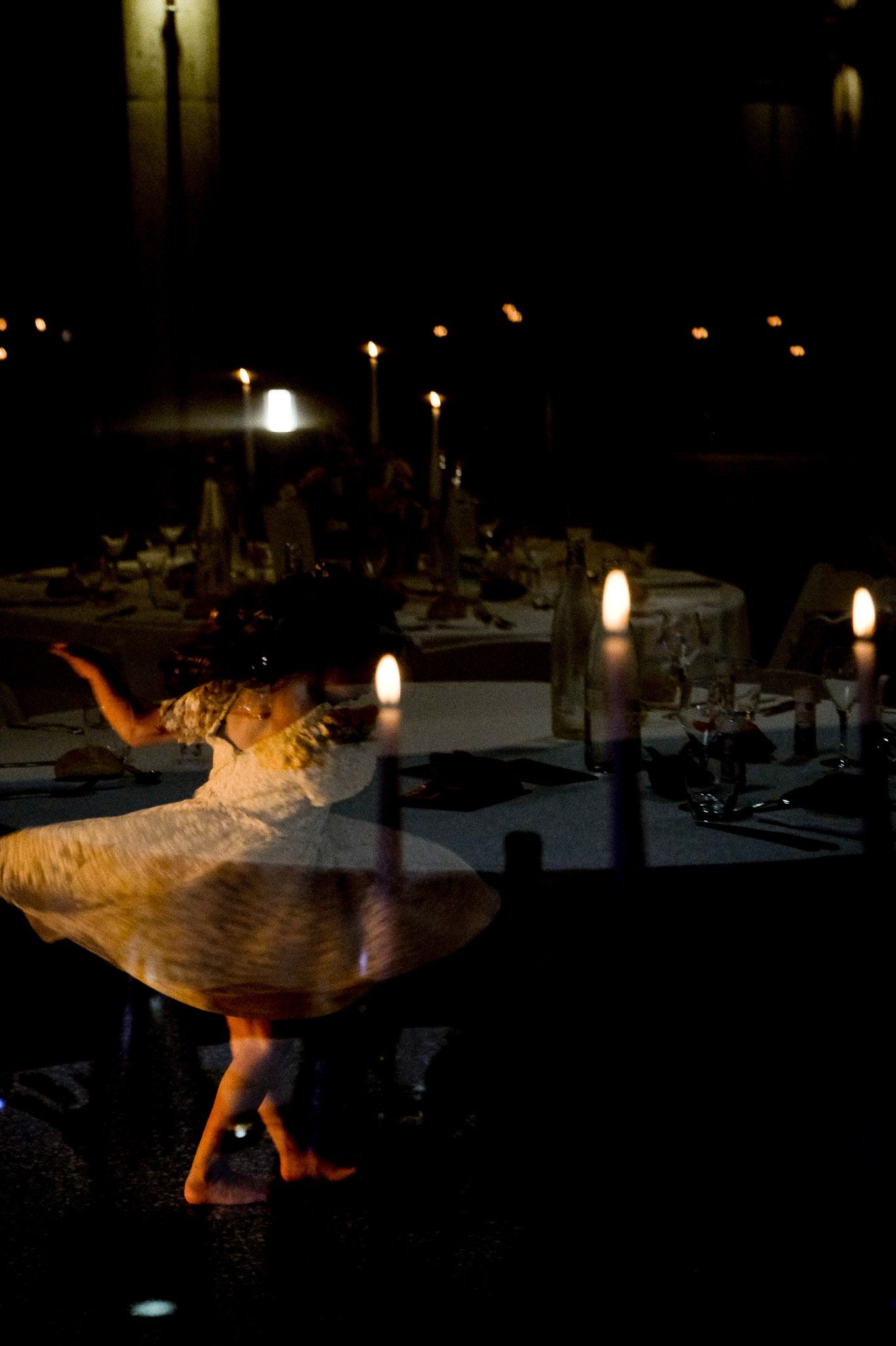 Petite fille dansant entre les bougies pendant un dîner de mariage – ambiance feutrée et festive