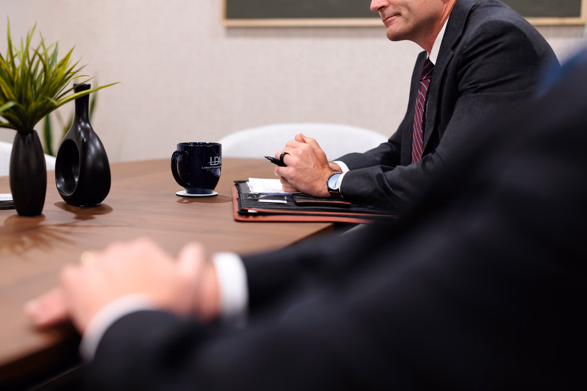 An image of an LDM attorney sat at a conference table for a meeting.