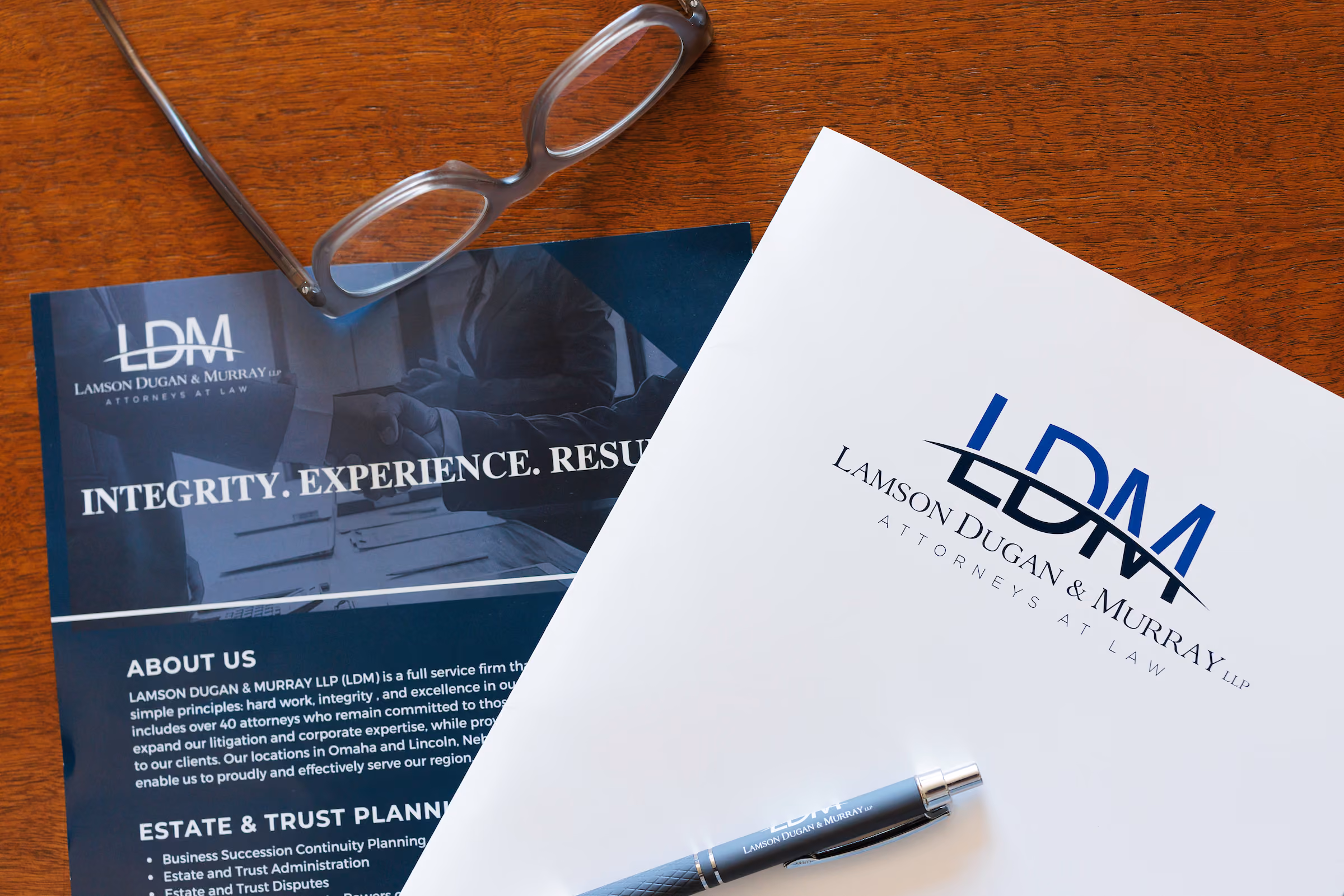 An overhead view of a flyer from LDM as well as their letterhead and a pen.