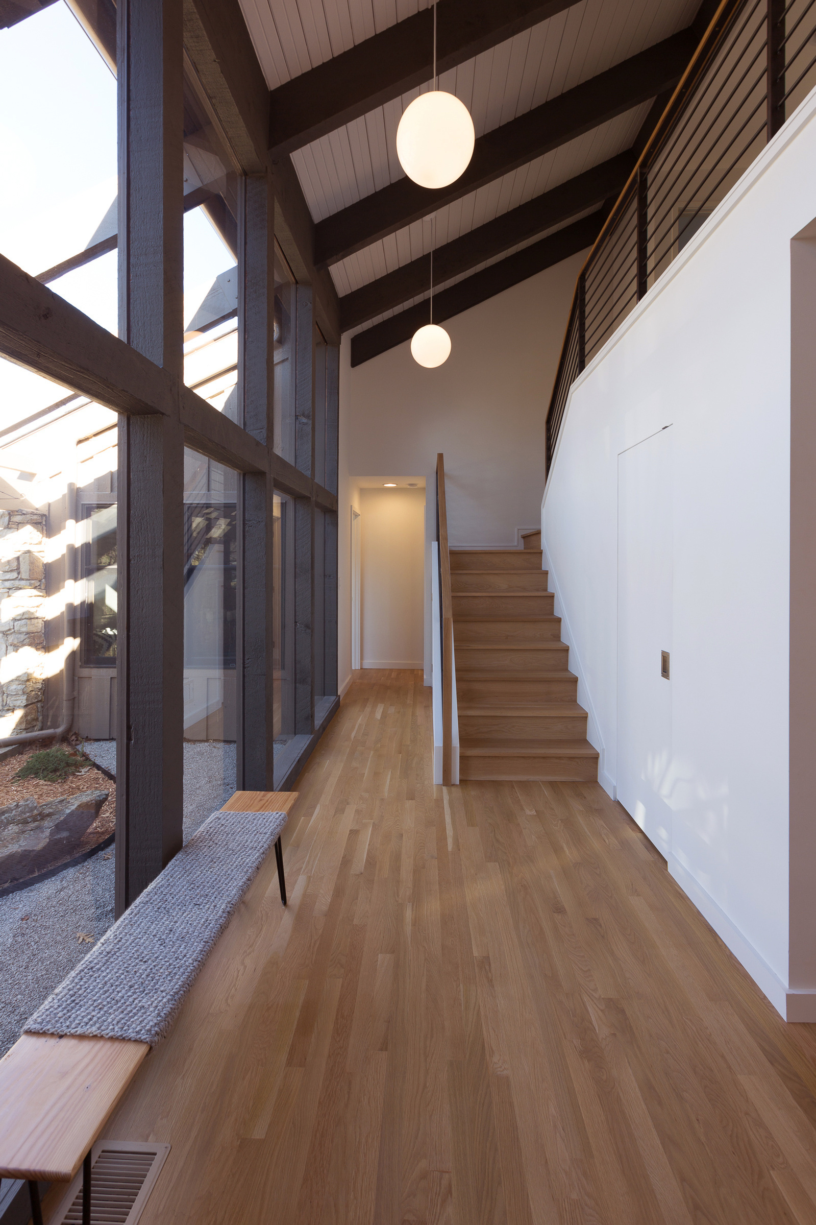 Mid-century modern interior with exposed beams and a glass wall, built by Faust Construction