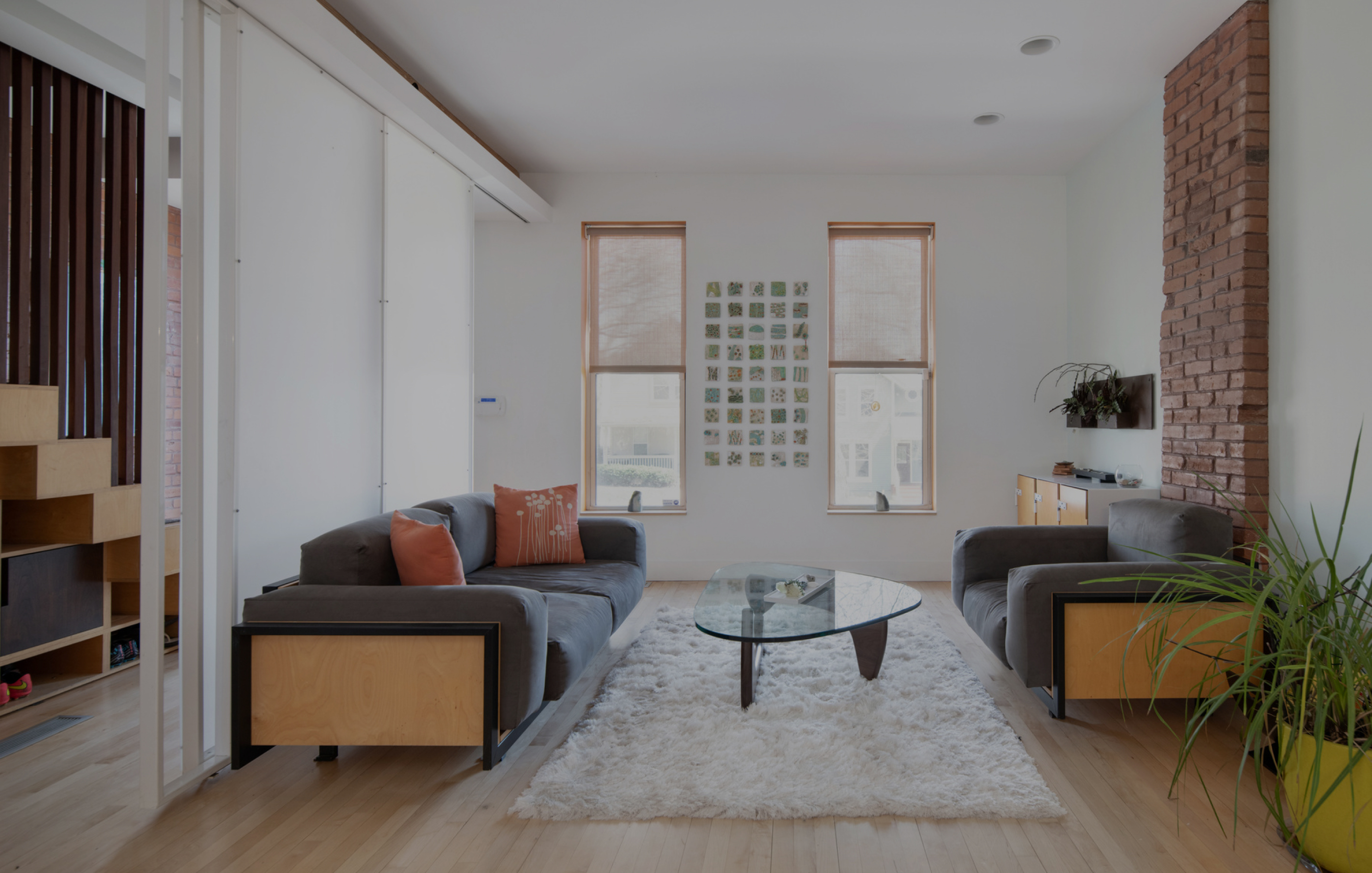 Renovated living room pairing original brick with new white oak and plaster, by Faust Construction
