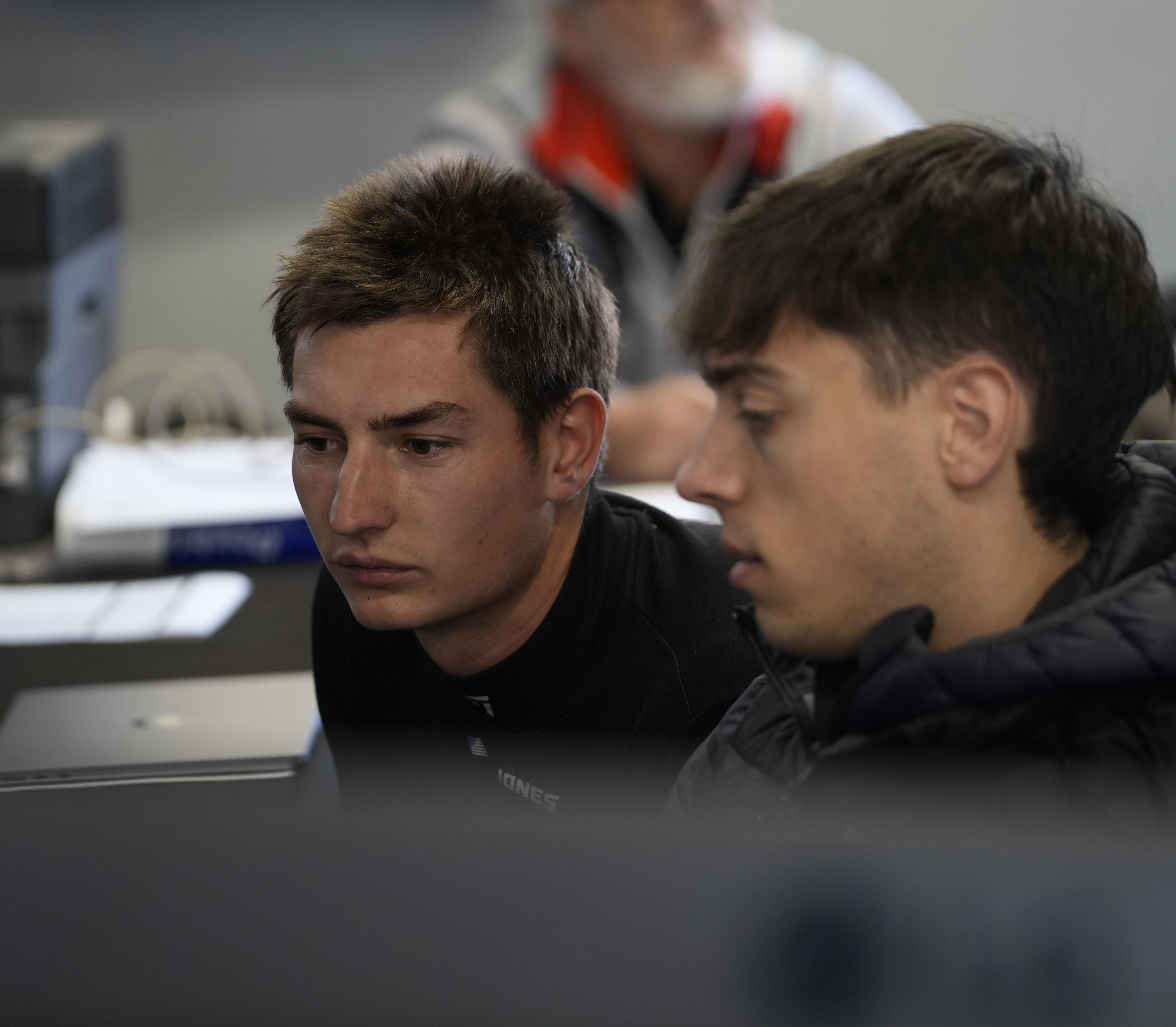 Remstar Racing drivers reviewing telemetry data during team debrief