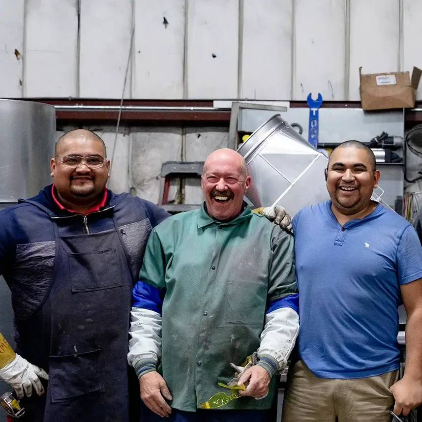 3 employees smiling in the shop.