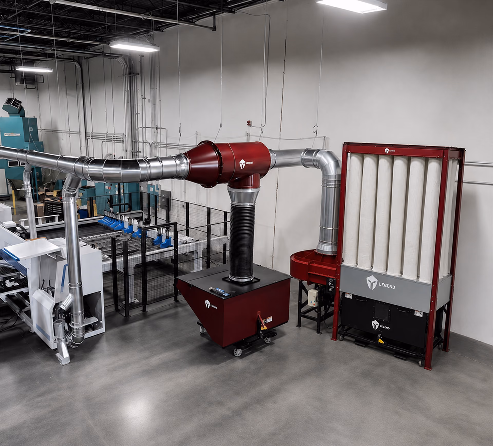 Indoor industrial dust collection system with red and silver ducting and fabric filter tubes on right.
