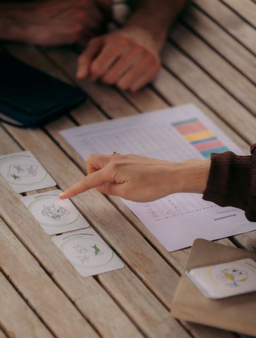 Hand wijst naar kerntalentenkaarten tijdens een coachingsessie – visuele begeleiding binnen persoonlijke ontwikkelingstrajecten bij Oraflow.
