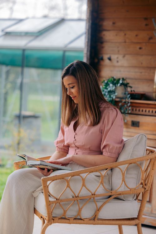 Laura, oprichter van OrafloW, leest geconcentreerd in een notitieboek in een rustgevende natuurlijke setting – begeleiding vanuit talent, flow en energie.