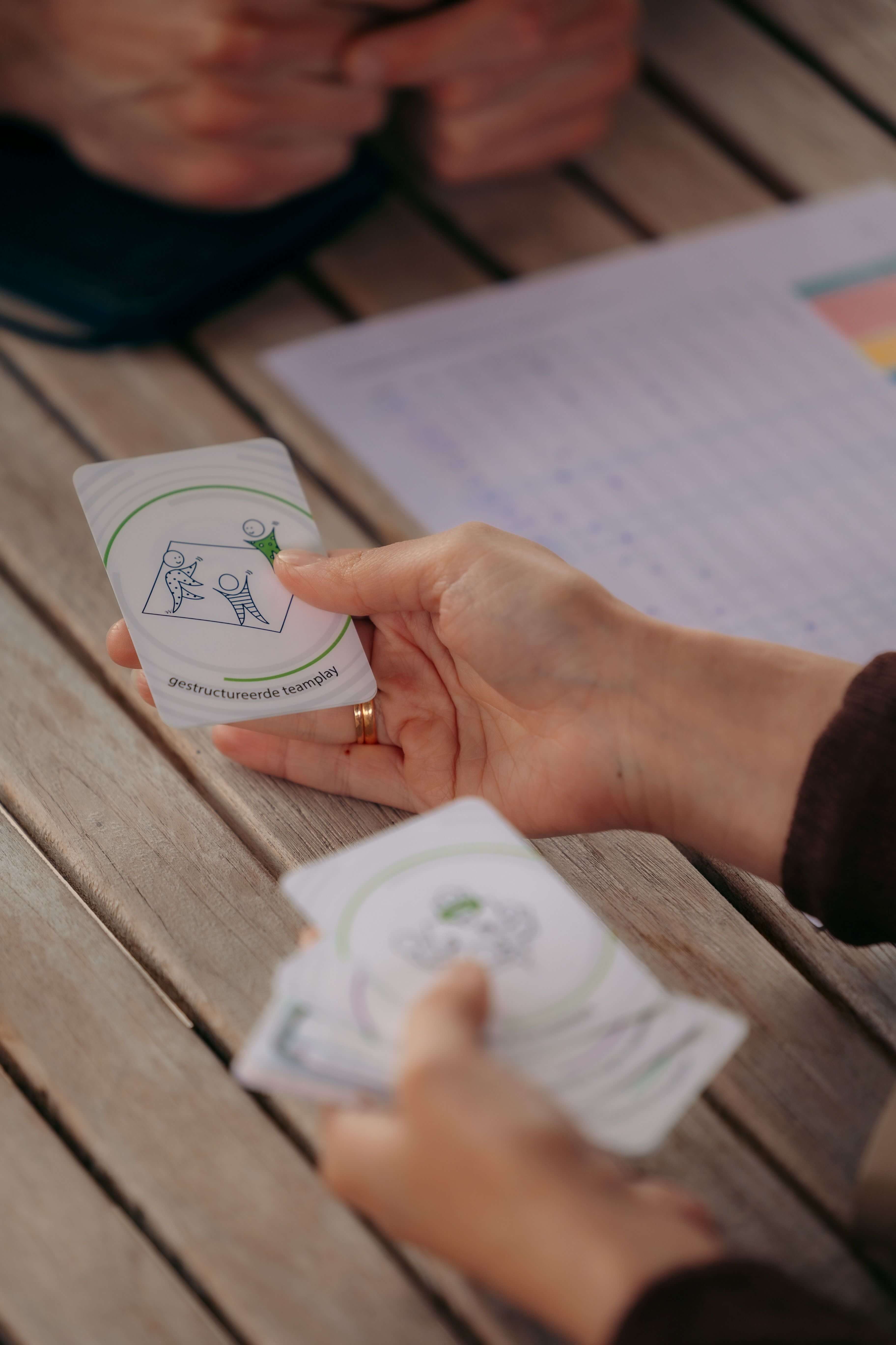 Hand met kerntalentenkaarten tijdens een kerntalentenanalyse – visuele begeleiding binnen persoonlijke ontwikkelingstrajecten bij Laura Gielis.