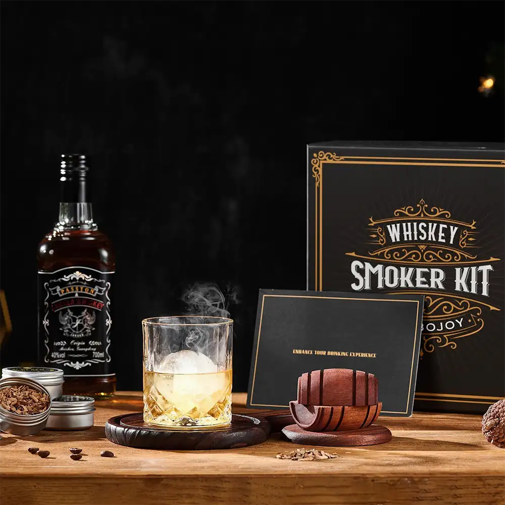 Whiskey Smoker Kit mit Holz-Räucherdeckel auf einem Glas, Räucherchips, Brenner und zwei Gläsern in einer Geschenkbox.
