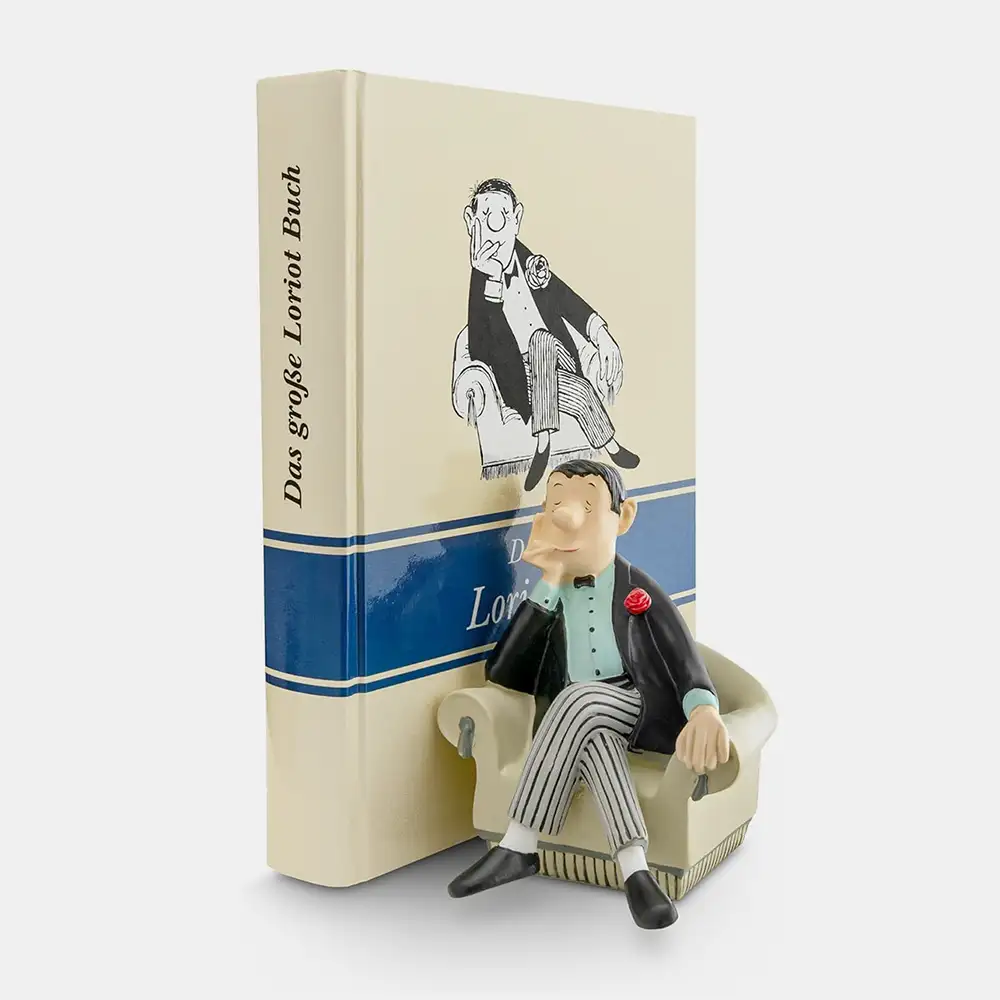 Handbemalte Loriot-Buchstütze „Herr im Sessel": ein Herr im Anzug, entspannt in einem Sessel sitzend, als Deko-Figur im Bücherregal.