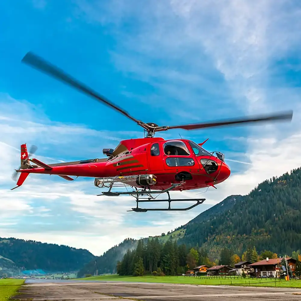 Hubschrauber im Tiefflug über eine grüne Landschaft während eines Jochen Schweizer-Rundflugs
