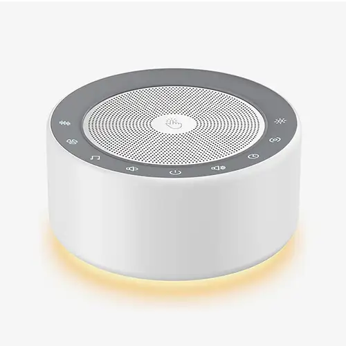 Kipcush White Noise Machine in Weiß mit dimmabarem Nachtlicht auf einem Nachttisch