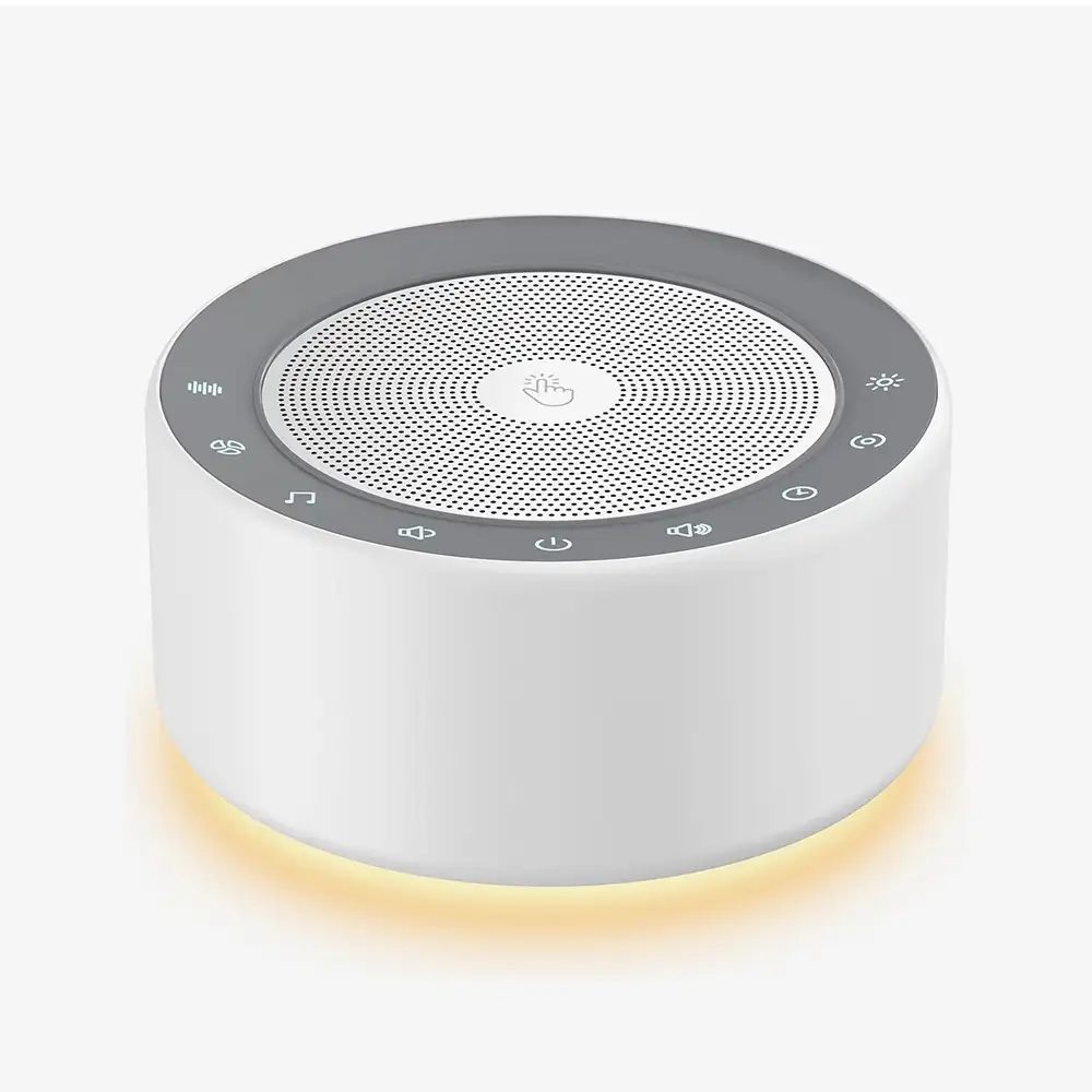 Kipcush White Noise Machine in Weiß mit dimmabarem Nachtlicht auf einem Nachttisch
