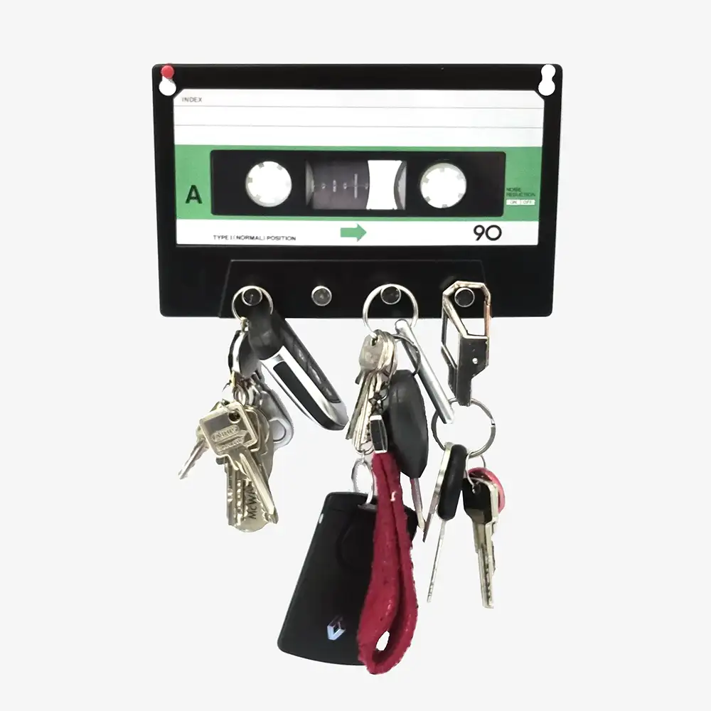 Schlüsselbrett in Form einer Musikkassette aus Metall mit vier Haken, montiert an heller Wand