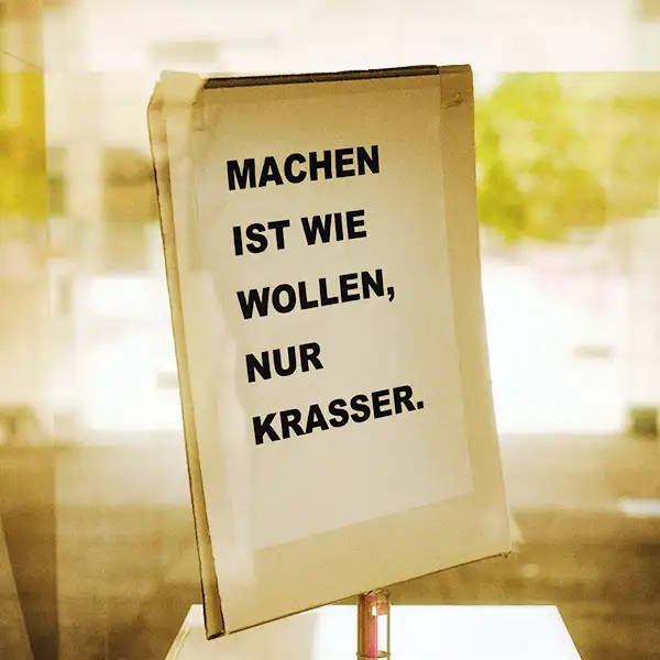 Schild mit Aufschrift "Machen ist wie wollen, nur krasser"