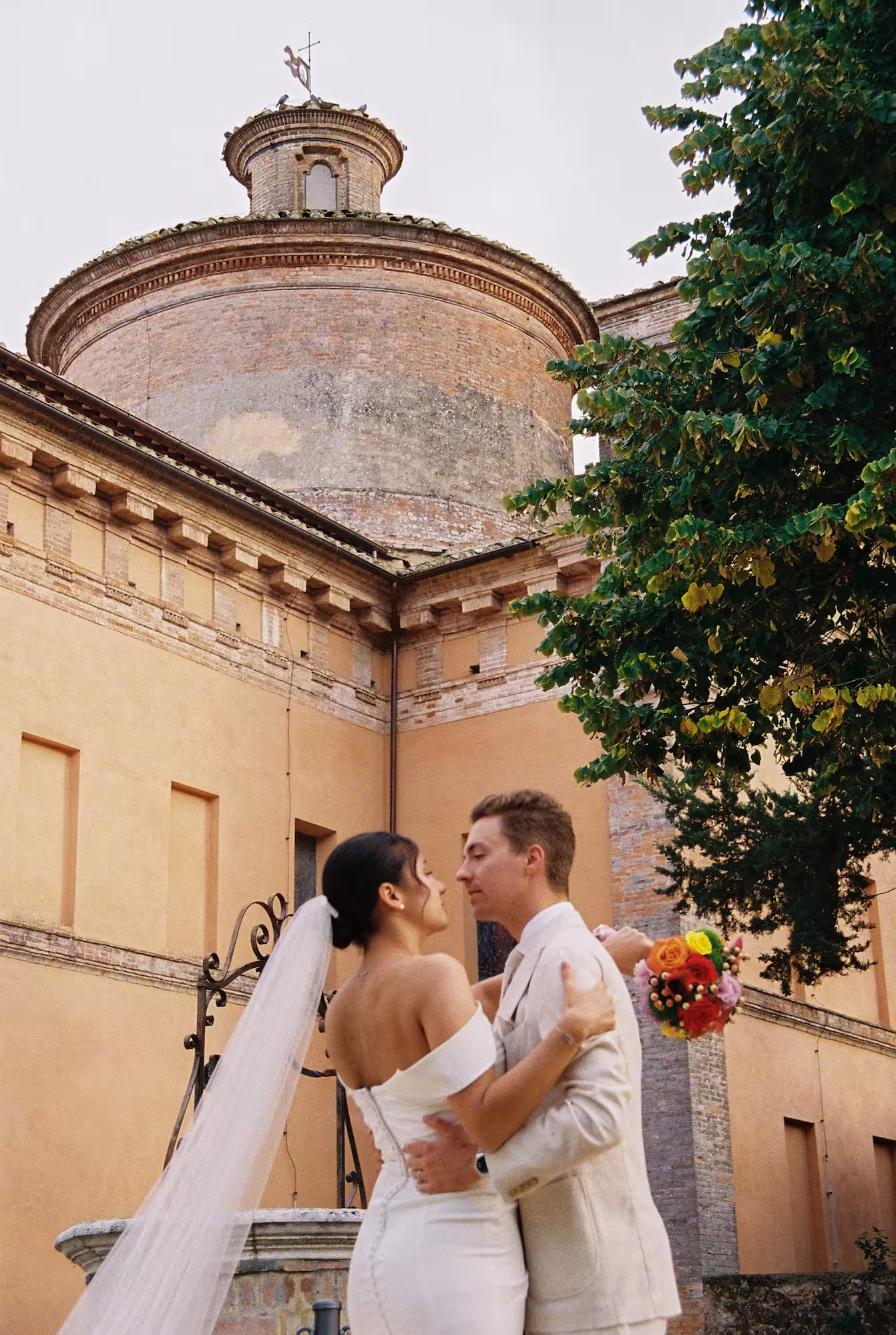 Léa et Thomas devant une église ancienne dans le Val d’Orcia pour leur mariage en Toscane