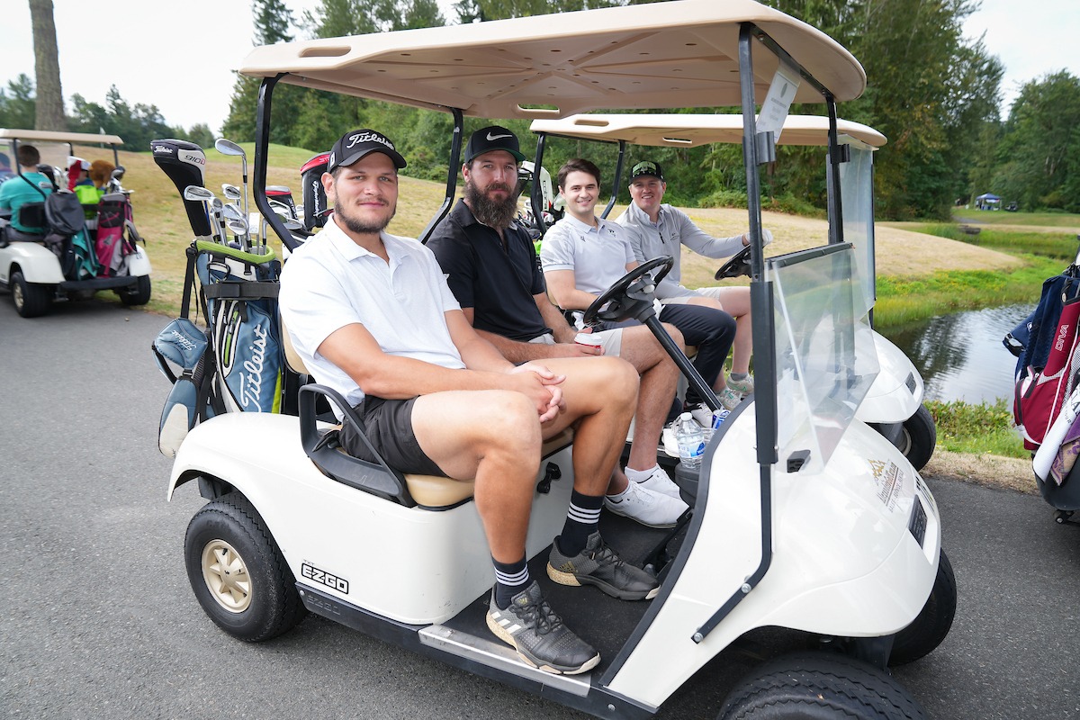 Guys in golf cart at a golf course