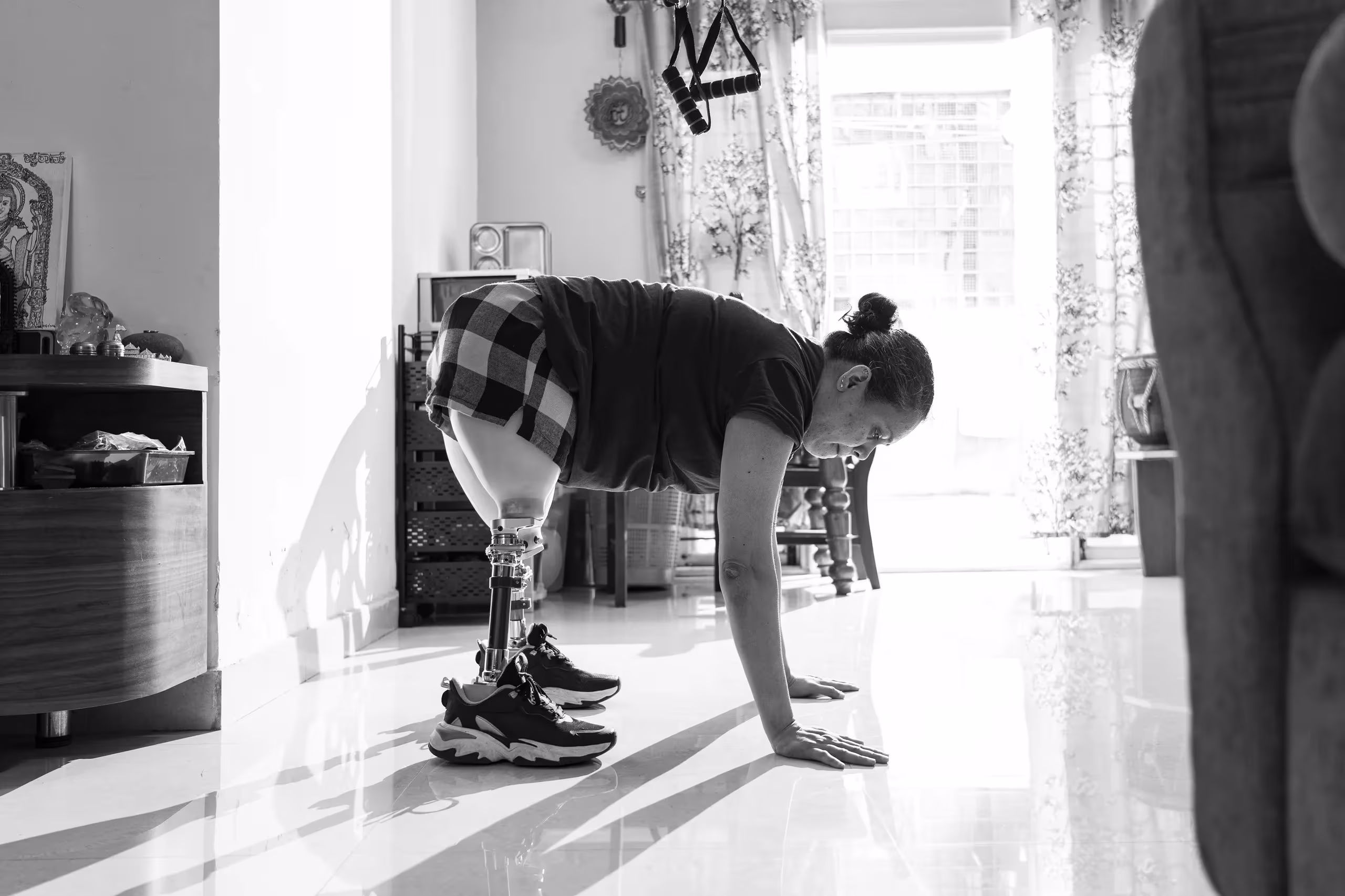 An amputee exercising and standing up in her living room